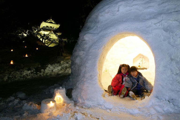 401121 05: Children sit in a snow hut, or kamakura, during the Kamakura Festival February 15, 2002 in the northern Japanese city of Yokote, Akita Prefecture, Japan. During the festival, tourists will be invited into snow huts and served sake and rice cakes. About 100 kamakura huts have been built in the city for the event. (Photo by Koichi Kamoshida/Getty Images)