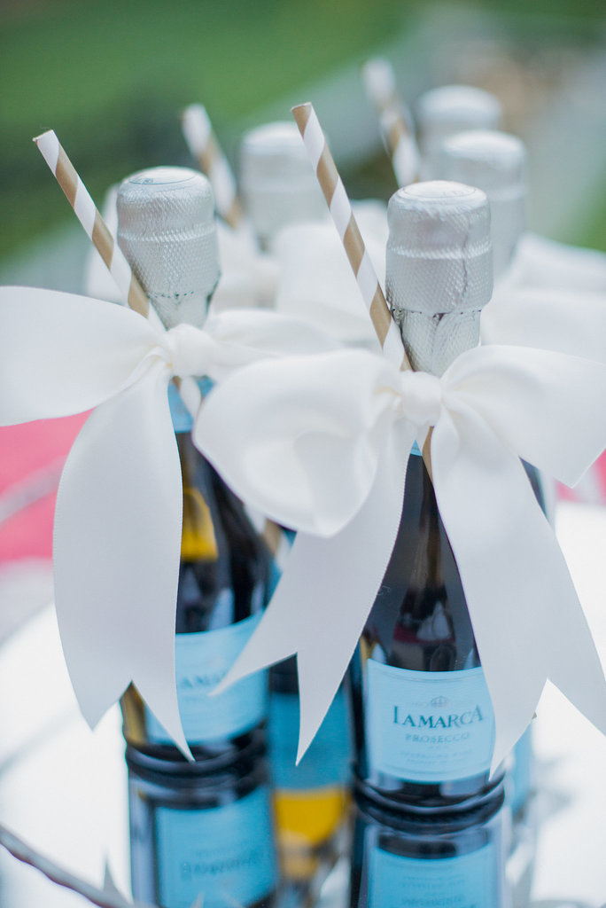 Give your guests a refreshment that's as tasty as it is adorable — ribbon-wrapped Champagne with gold straws.