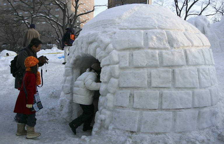 SAPPORO, JAPAN - FEBRUARY 12: Children enter an igloo during the 57th Sapporo Snow Festival February 12, 2006 in Sapporo, Hokkaido, Japan. Two million people are expected to visit the annual week long festival featuring snow and ice scupltures from around the world, it is the largest winter attraction in Hokkaido. (Photo by Cameron Spencer/Getty Images)