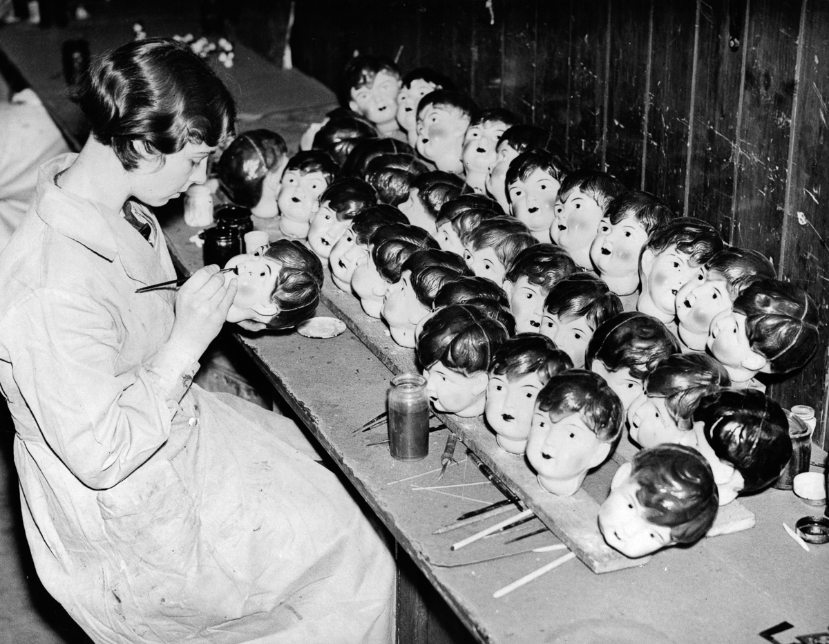 18th December 1935: A worker painting celluloid dolls heads at a factory in Leicester. (Photo by Harry Todd/Fox Photos/Getty Images)