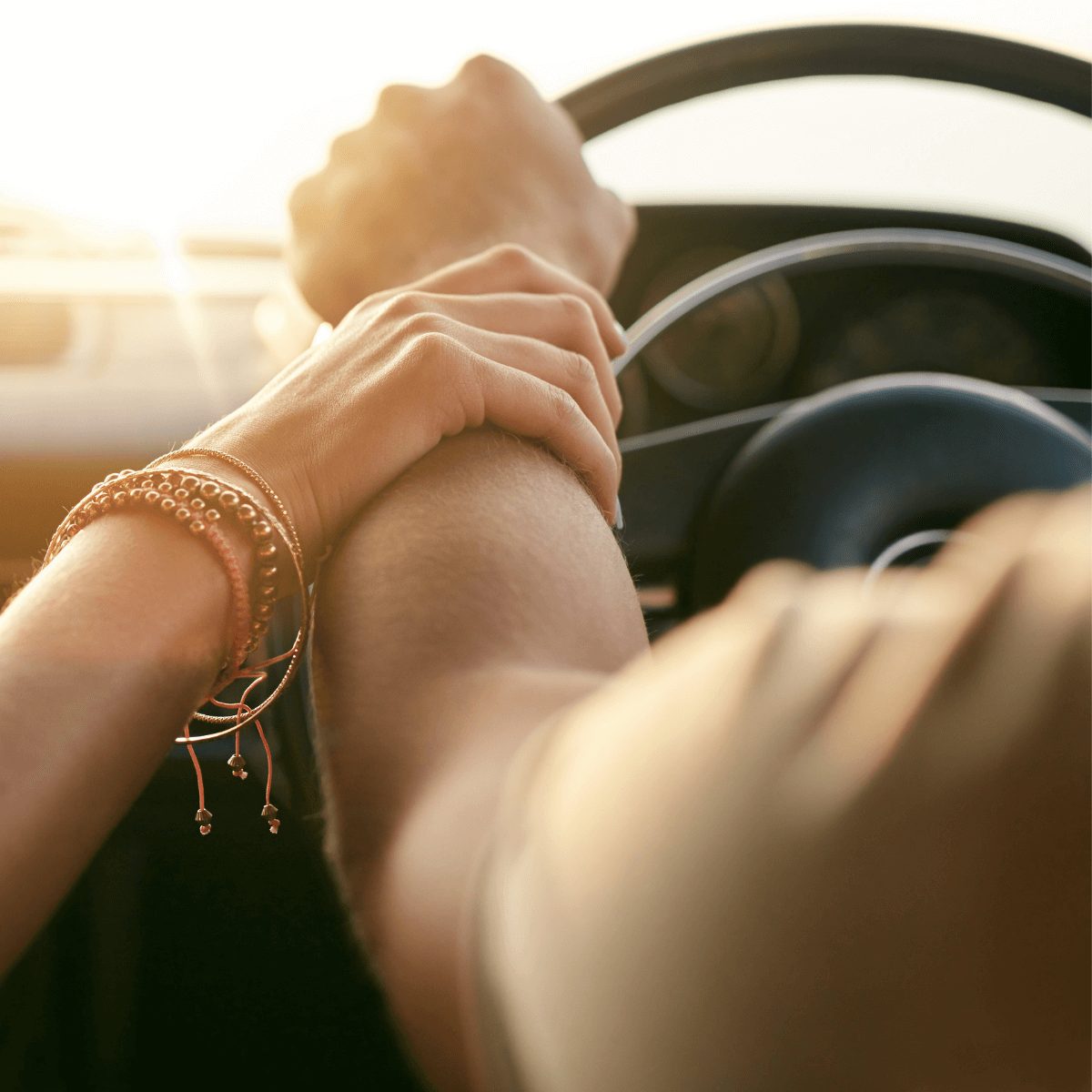 kobieca ręka trzymająca rękę mężczyzny kierującego autem