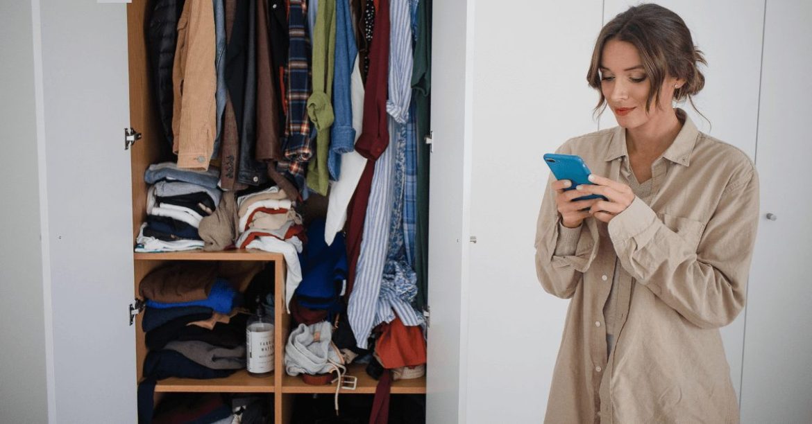 dziewczyna przgeglądająca telefon na tle szafy