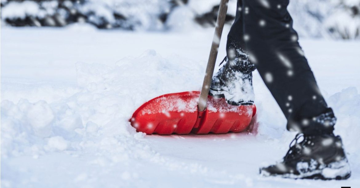 człowiek odgarniający śnieg