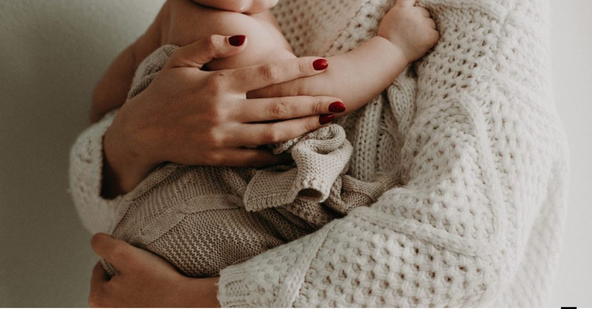 mama trzymająca w ramionach dziecko