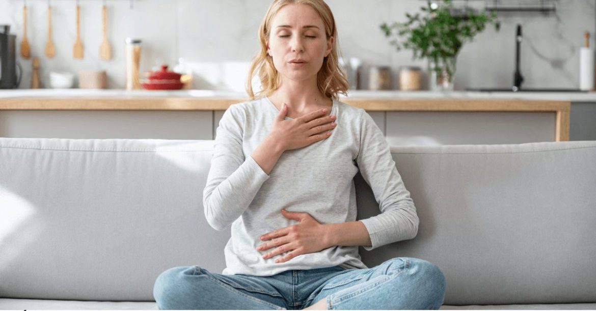 kobieta siedząca na kanapie i głęboko oddychająca