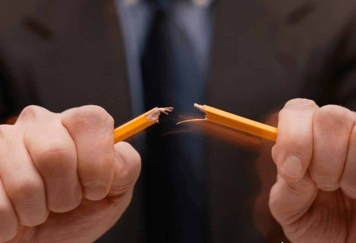 dłoń łamiąca ołówek