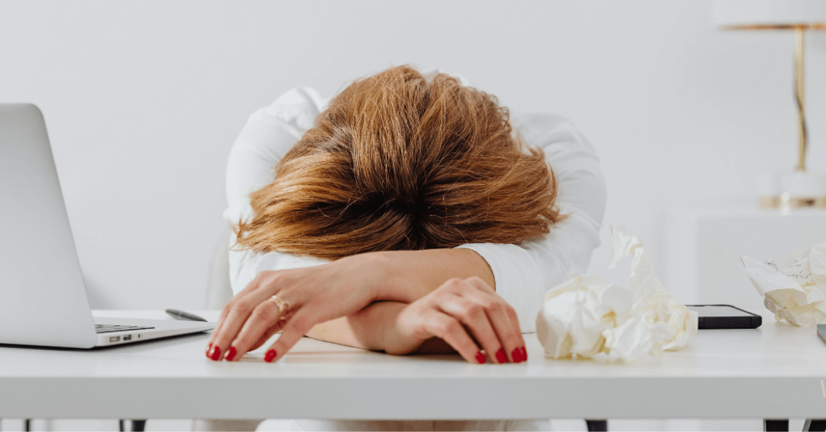 zmęczona kobieta z głową na biurku