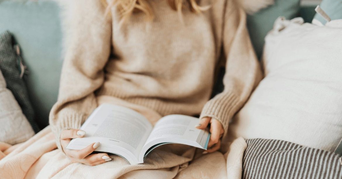 kobieta trzymająca książkę na kolanach