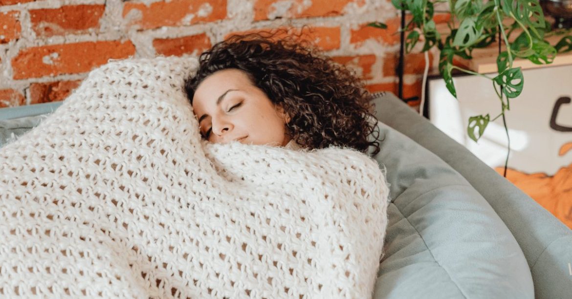 laska zawinięta w koc na kanapie