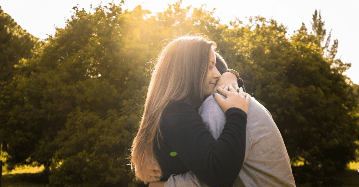 para przytulająca się na tle drzew